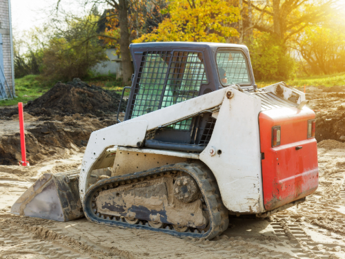 Small, bobcat style excavator.